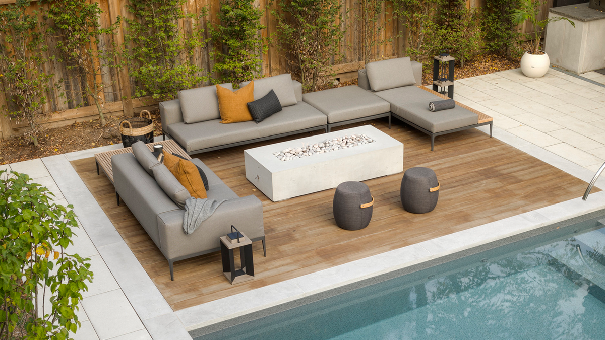 gloster grid sectional with fire pit in front of pool