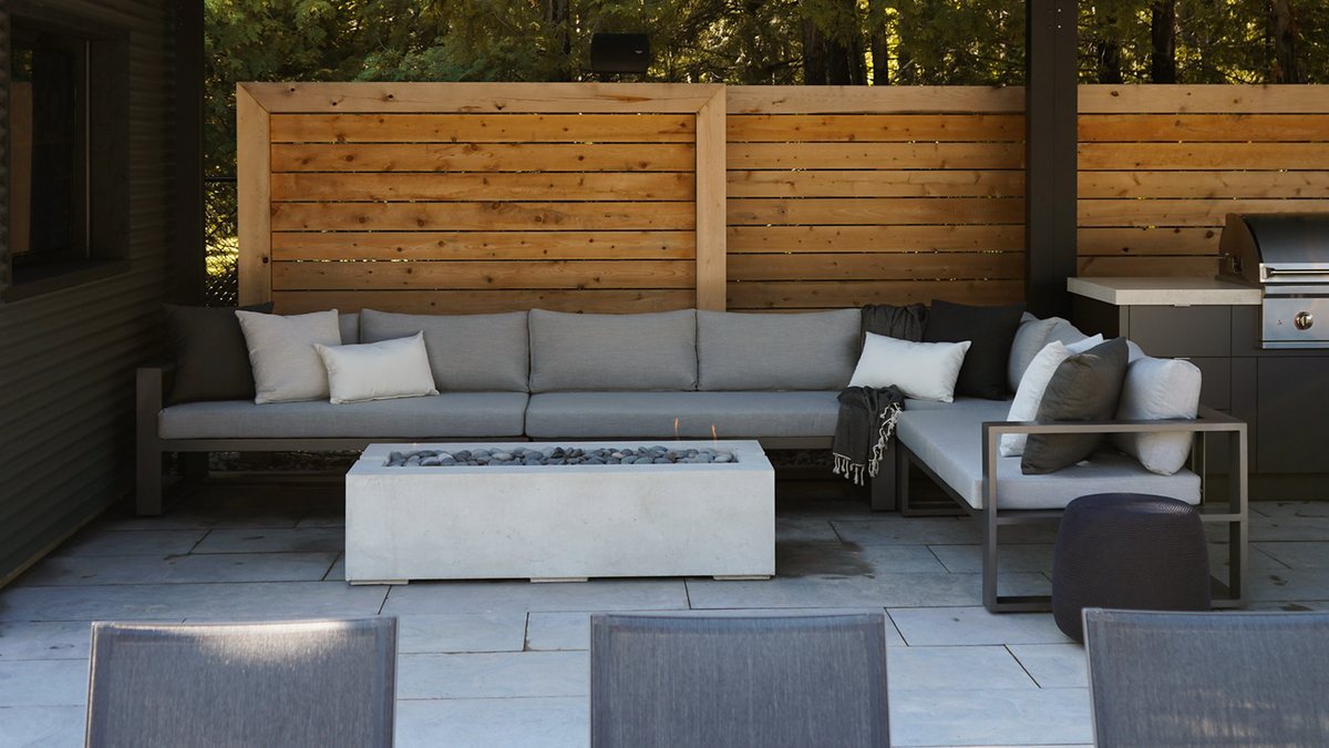 Quantum crate-style outdoor sectional in gunmetal grey finish on concrete patio