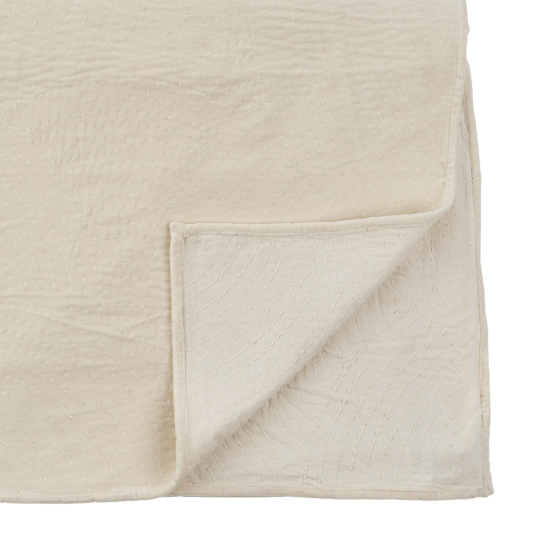 A folded cream-colored cotton bed blanket with a textured pattern on a white background.