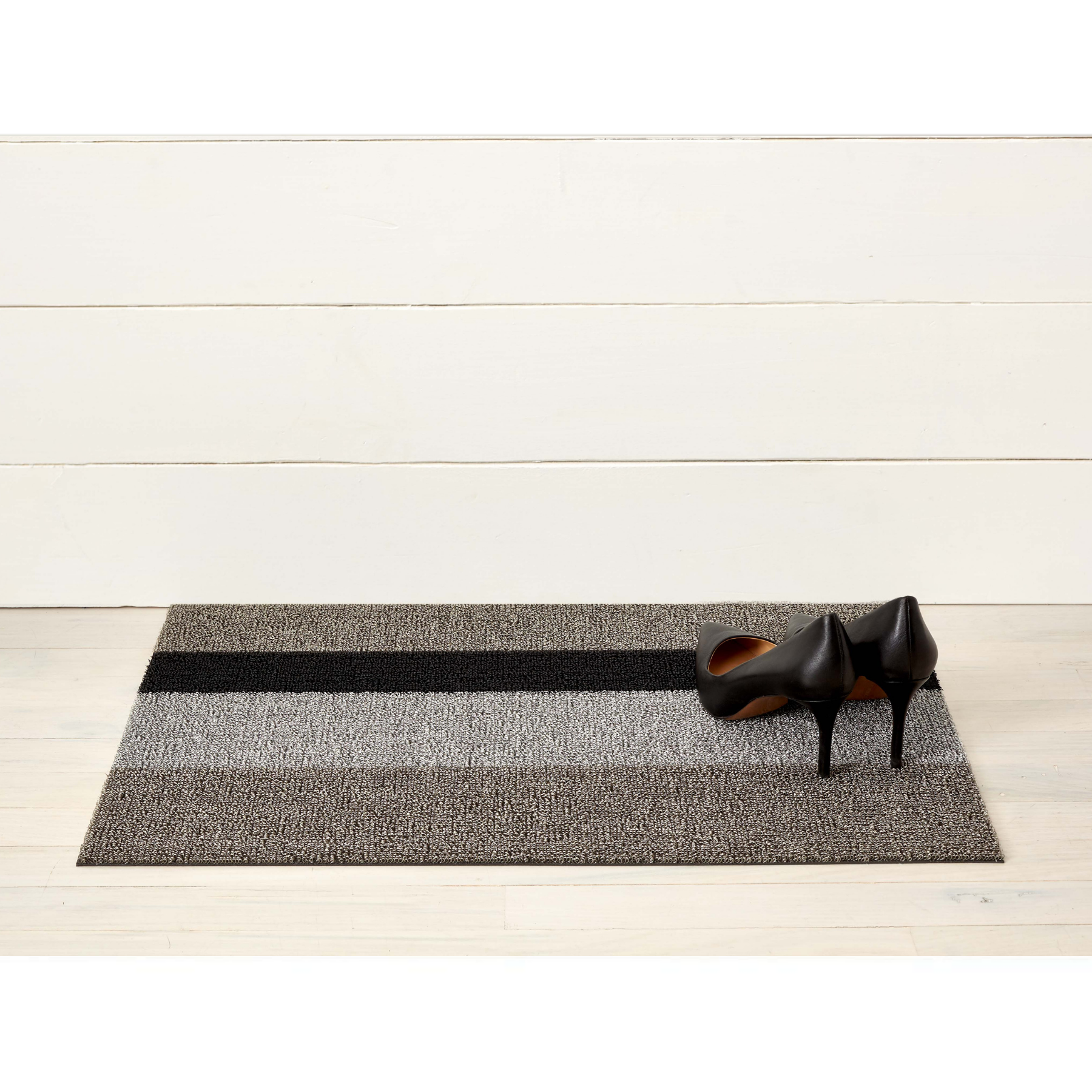Premium indoor and outdoor doormat, made from tufted, vinyl yarns with a vinyl backing. Thick striped patterns in dark grey, light grey and black.