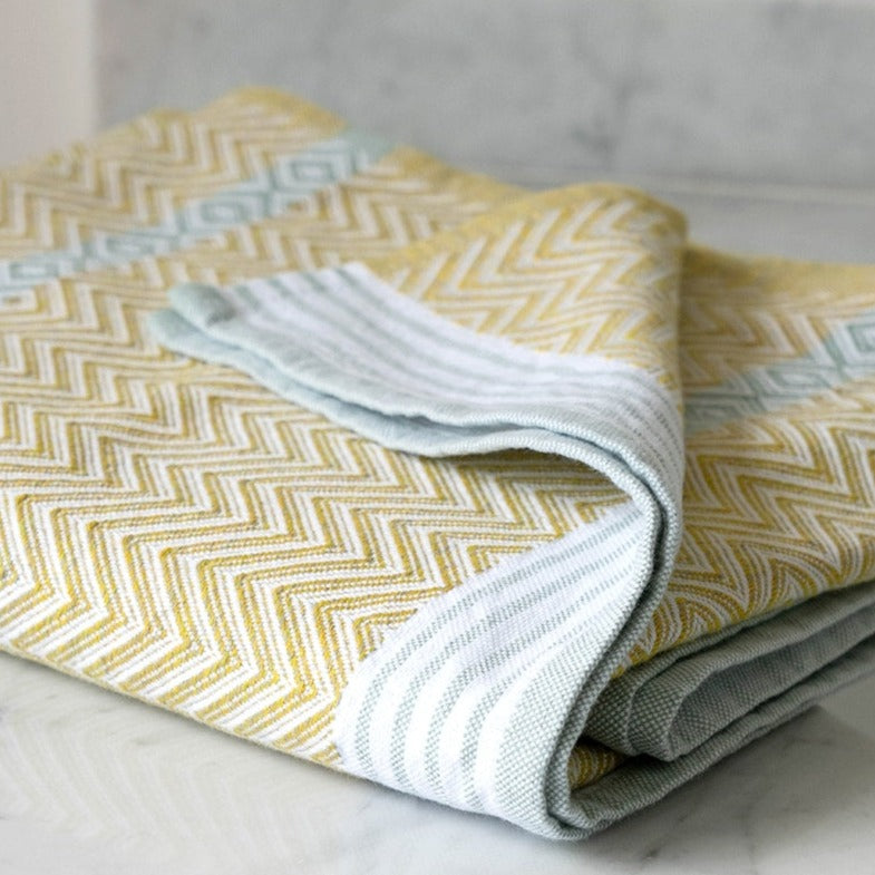 Premium one of kind cotton lemon coloured hand towel, intricate chevron pattern in warm yellow and banded with white and grey stripes at edge