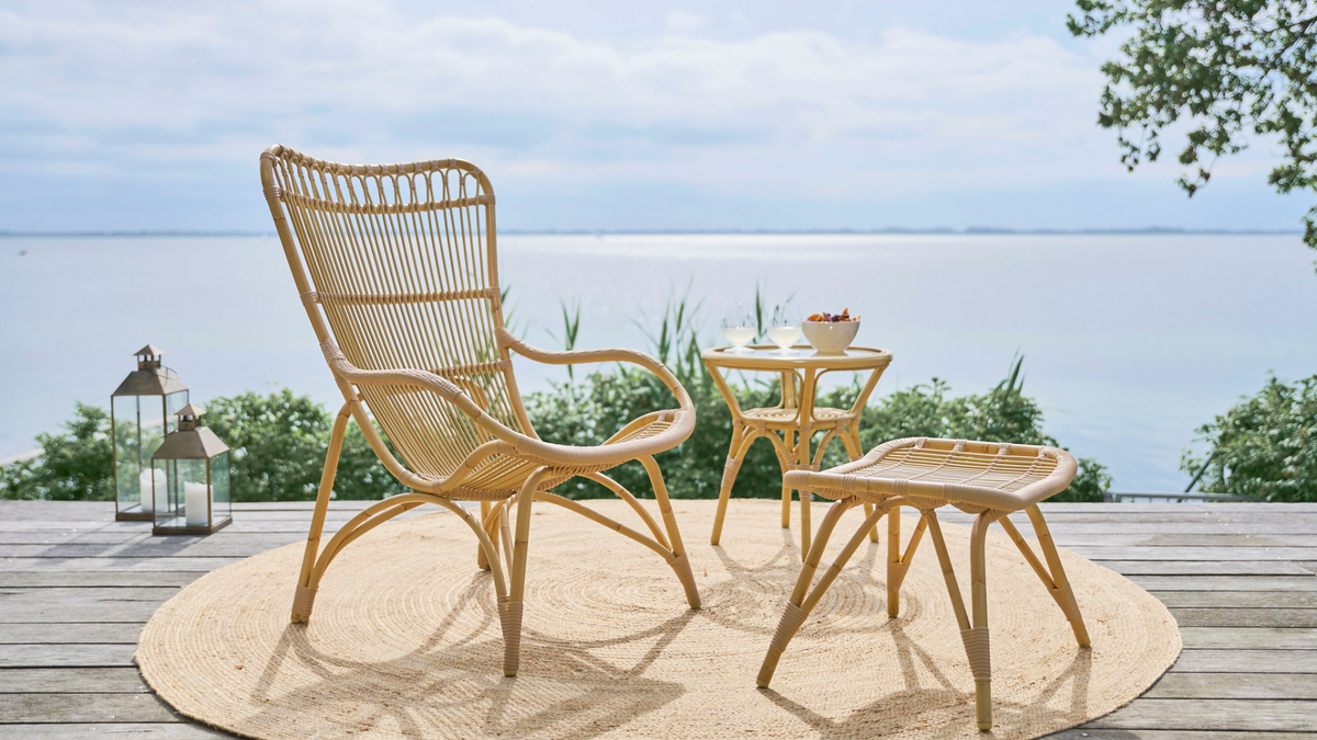 Courtyard outdoor white faux-rattan dining set and teak table on the beach