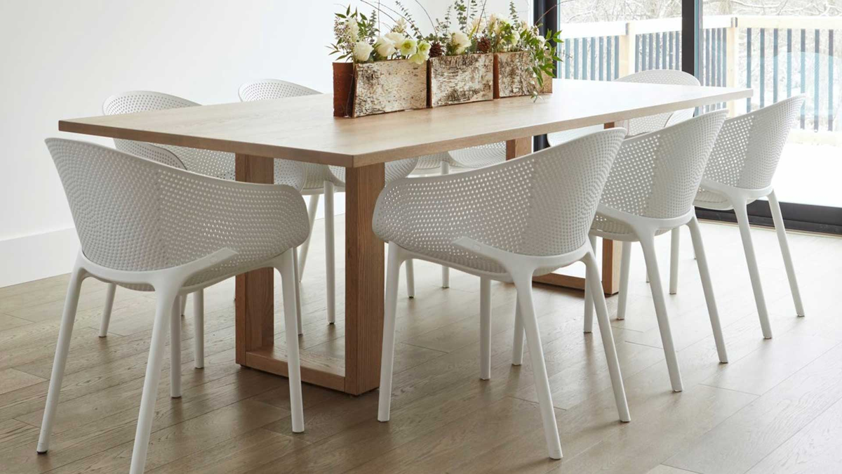 White resin indoor dining chairs around wood table