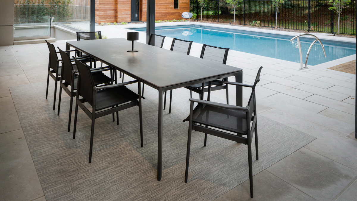 gloster meteor black dining table beside pool