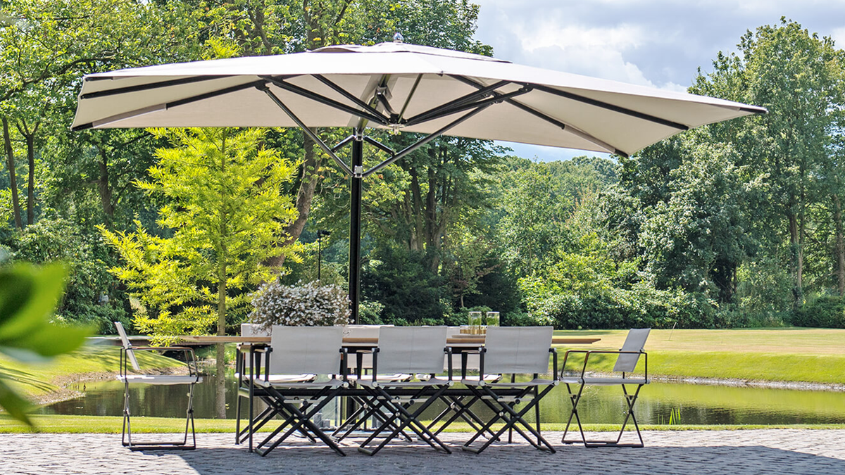 outdoor patio set with cantilever umbrella by pond
