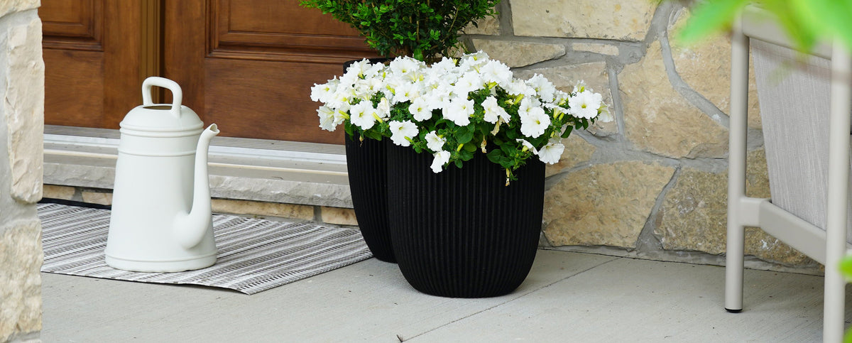 White kettle-shaped watering can and black planters