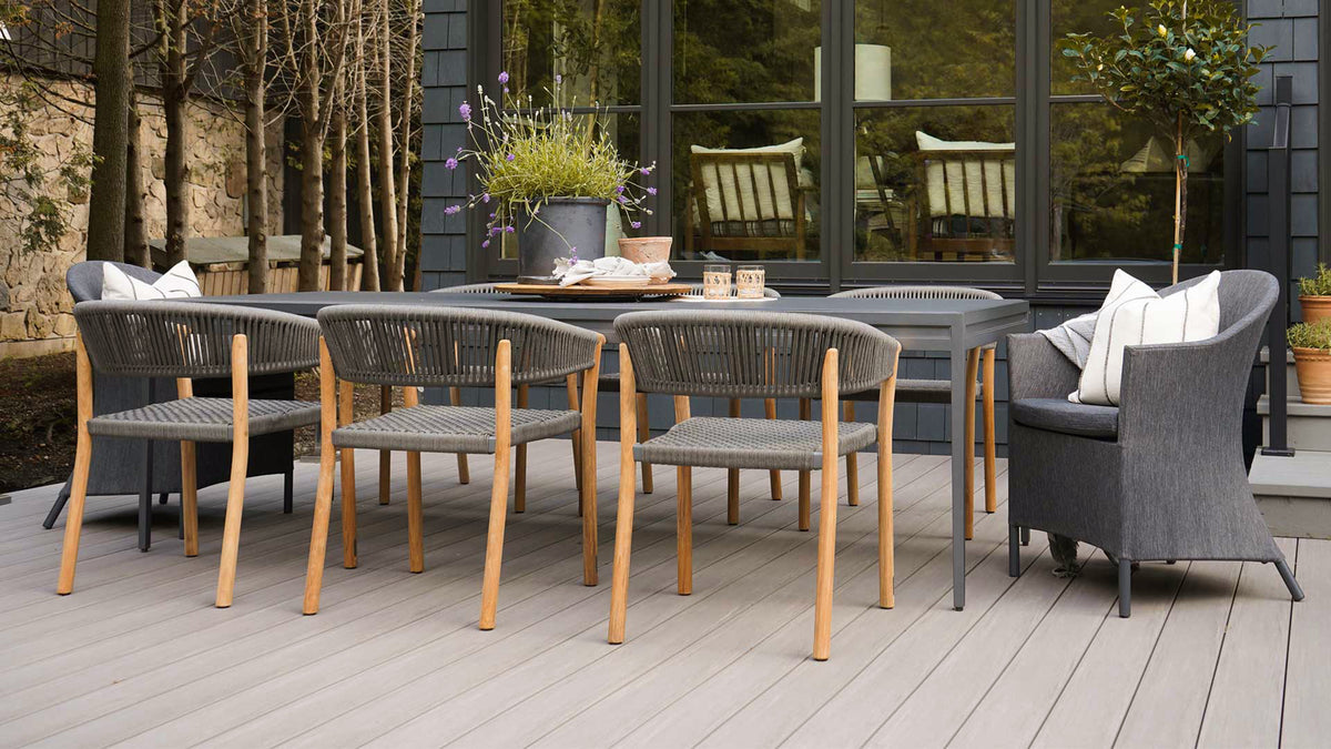 long 8 person outdoor grey table with modern teak and grey rope dining chairs