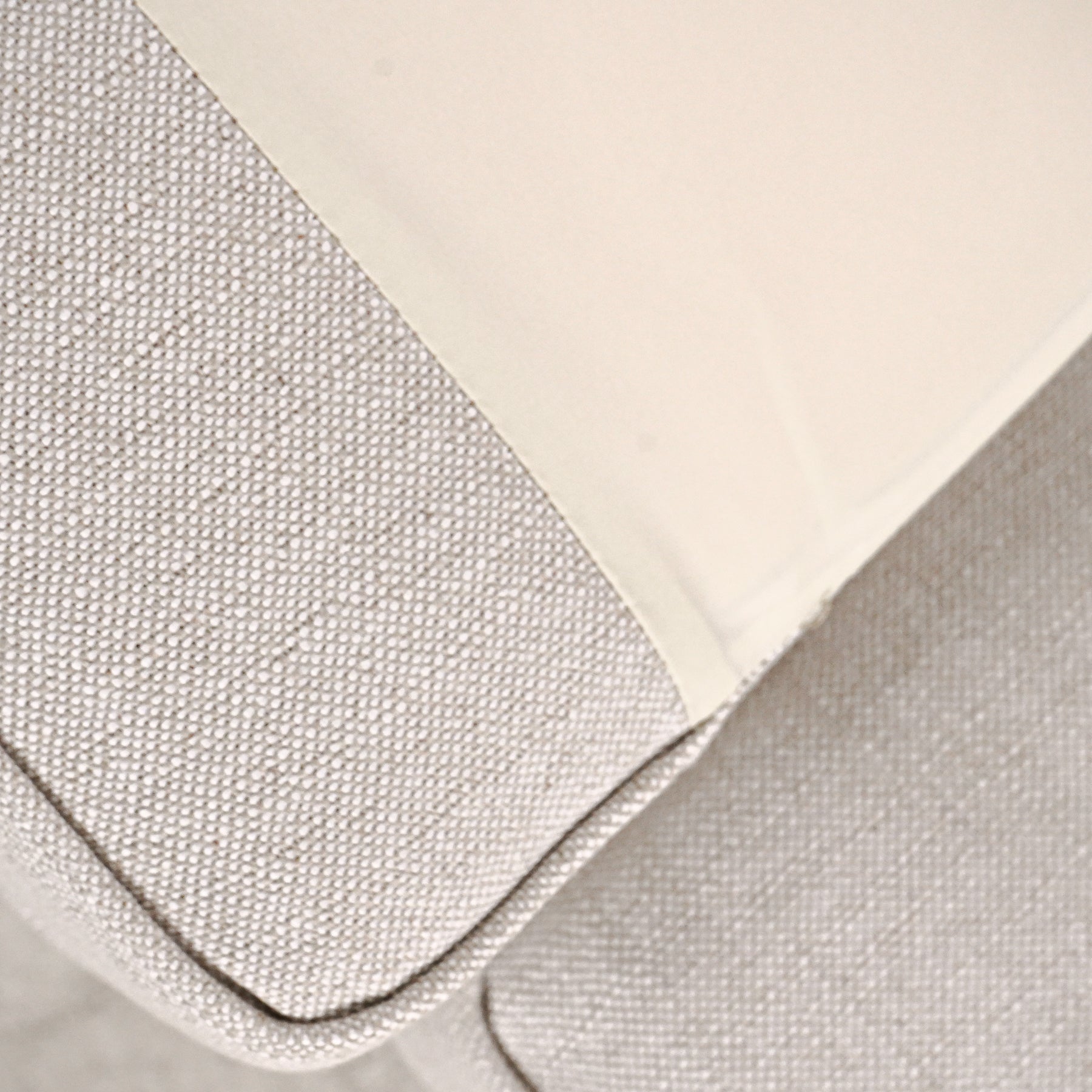 Close-up of textured fabric with a checkered pattern on a beige background