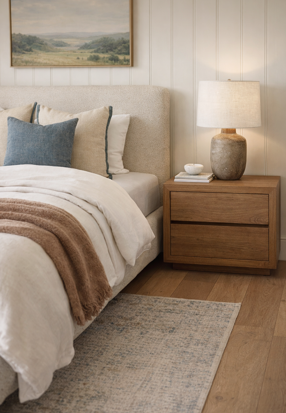 Cozy bedroom with a bed, nightstand, and lamp.