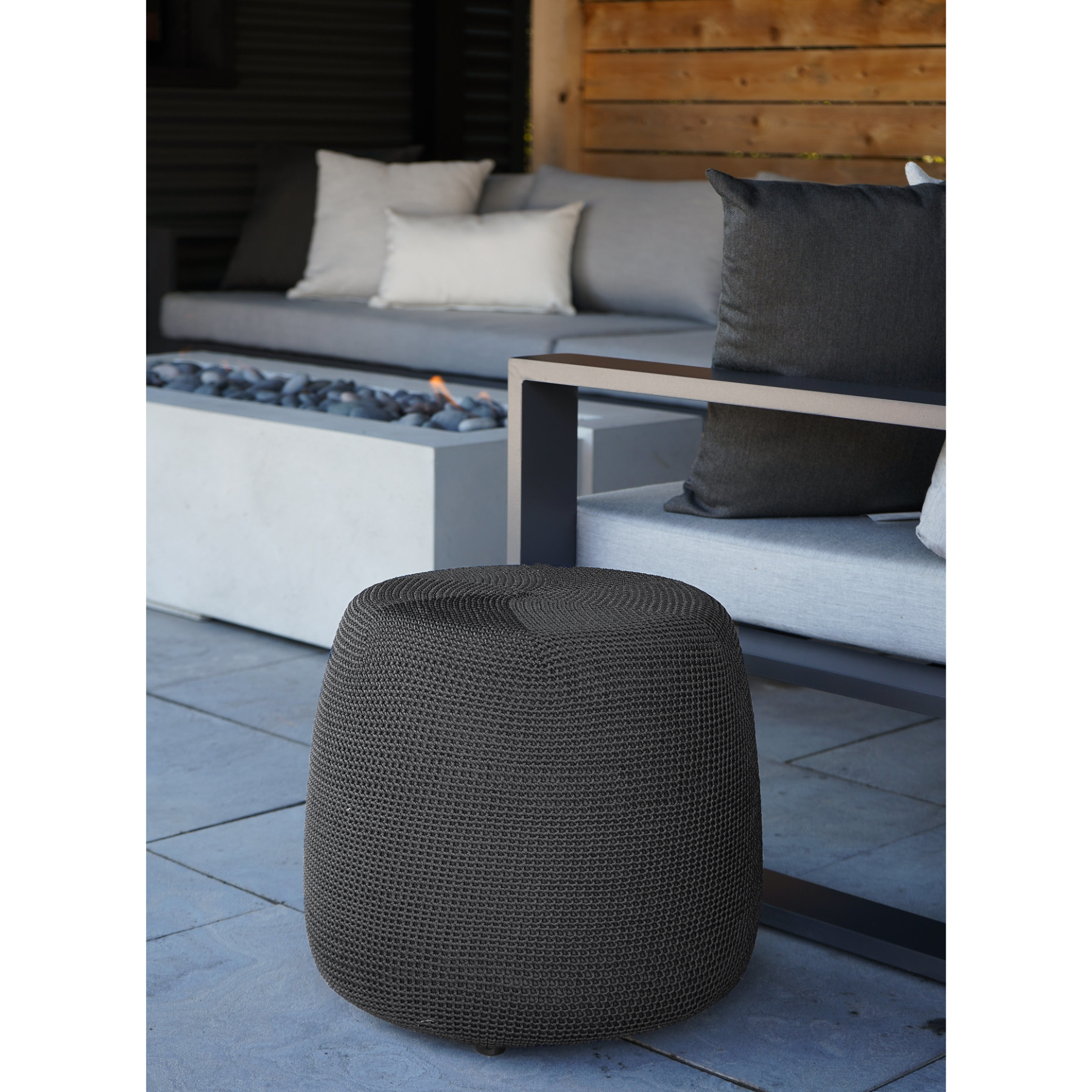 Premium indoor and outdoor crochet style footstool, crafted from woven polypropylene. The charcoal grey ottoman comes in an noval shape with a flat top. A tri stitching design runs along the top.