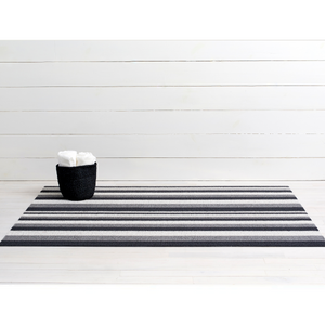 Premium indoor and outdoor doormat, made from tufted, vinyl yarns with a vinyl backing.  Narrow and thick striped pattern in dark grey, black and light grey colours. 
