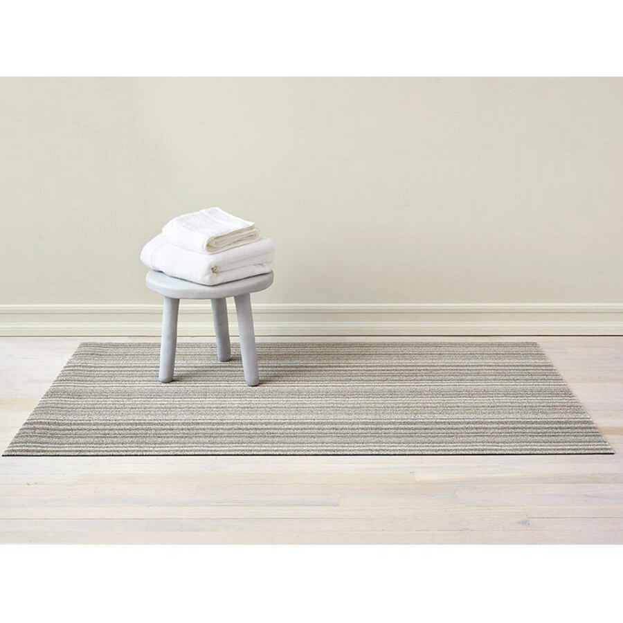 Premium indoor and outdoor rug, made from terrastrand yarns with a slip-resistant latex backing. A heathered rug blends shades of light grey with speckles of white, in a weave design.